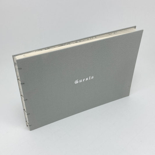 silver gray guest book with foil 'Guest' embossed on a light gray background