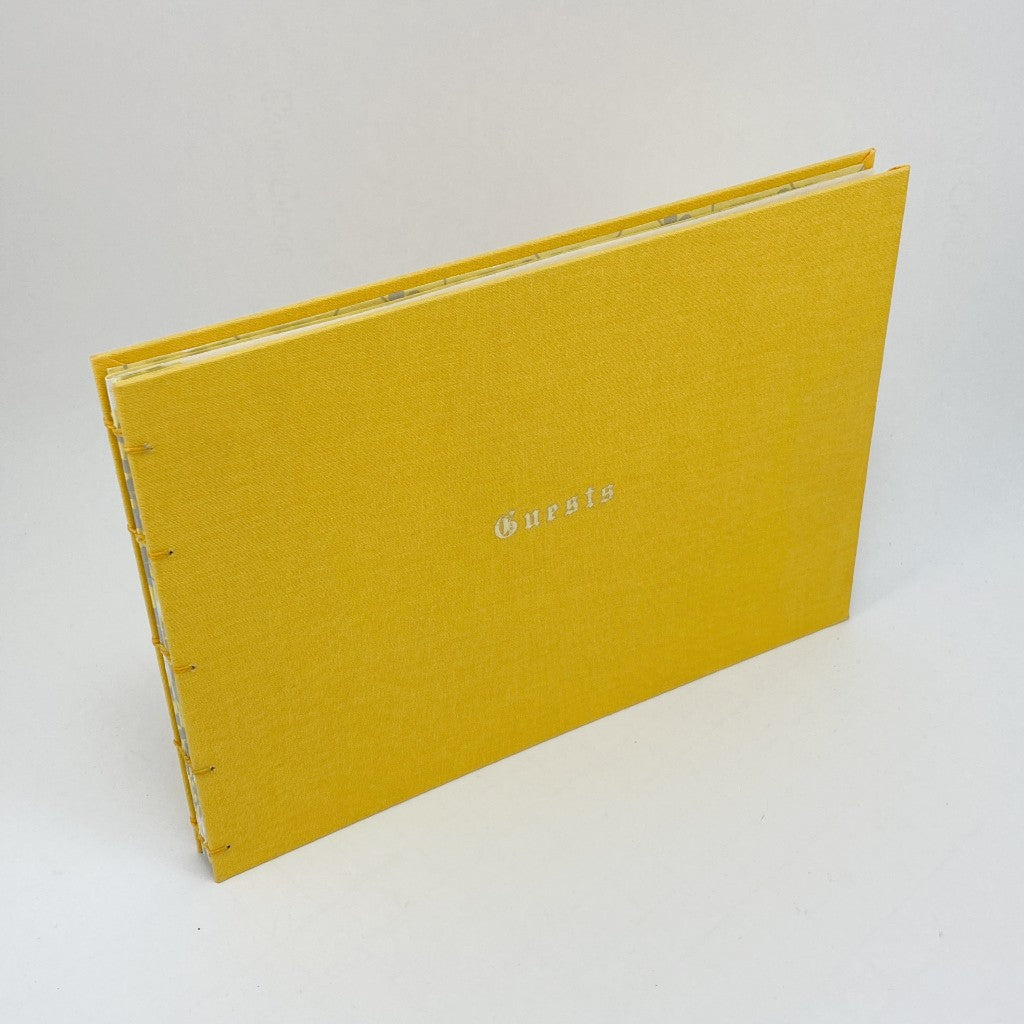 Yellow guest book with yellow covers and floral interior design and blank pages