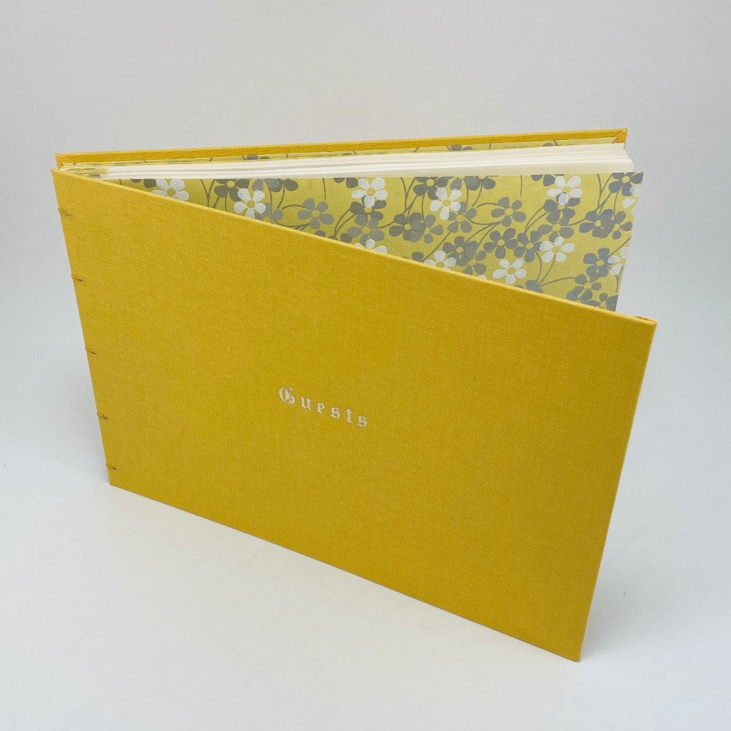 Yellow guest book with yellow covers and floral interior design and blank pages