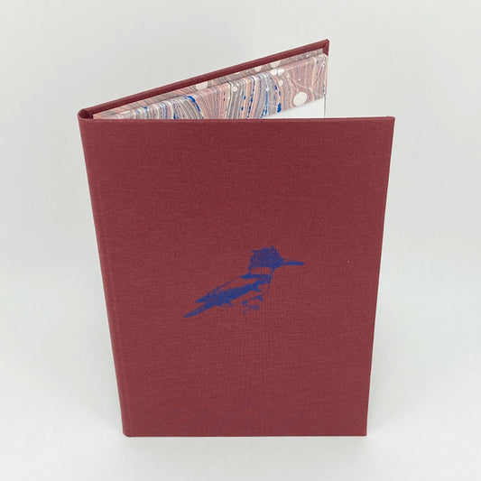 Red notebook with a blue bird illustration on a white background