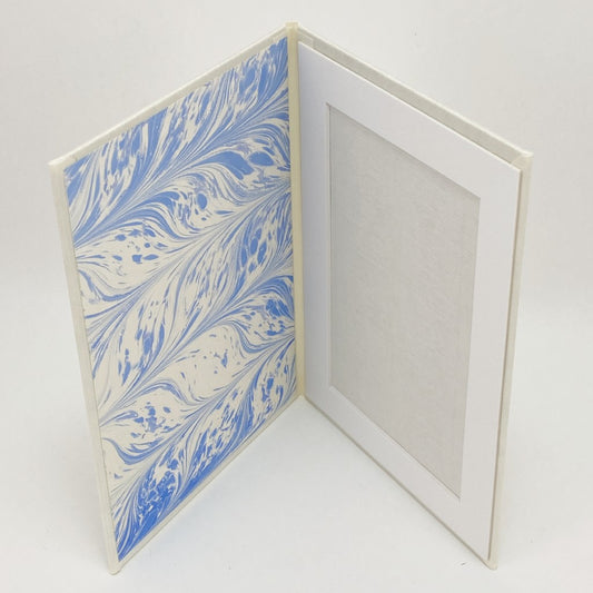 Marbled blue and white photo frame with a white border on a light gray background